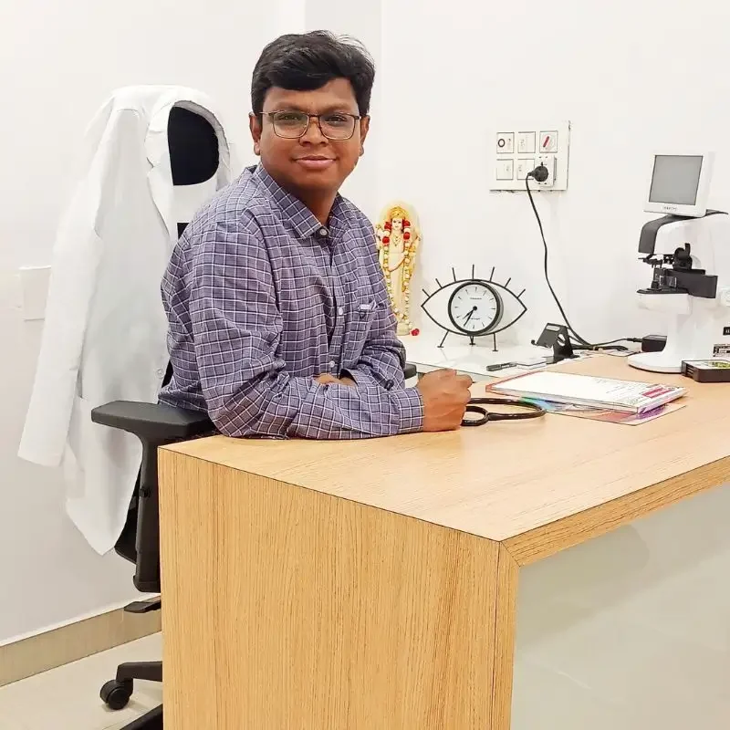 Dr. Nikhil Govindwar sitting at his desk with his white appron hanging on his chair.